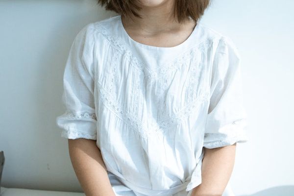 Child sitting calmly in a lotus pose with a smile.