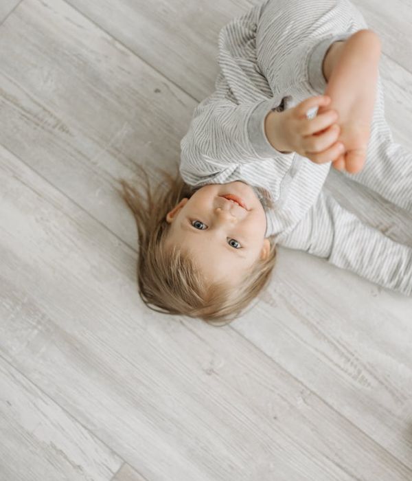 Happy child in a simple yoga pose in a bright room.